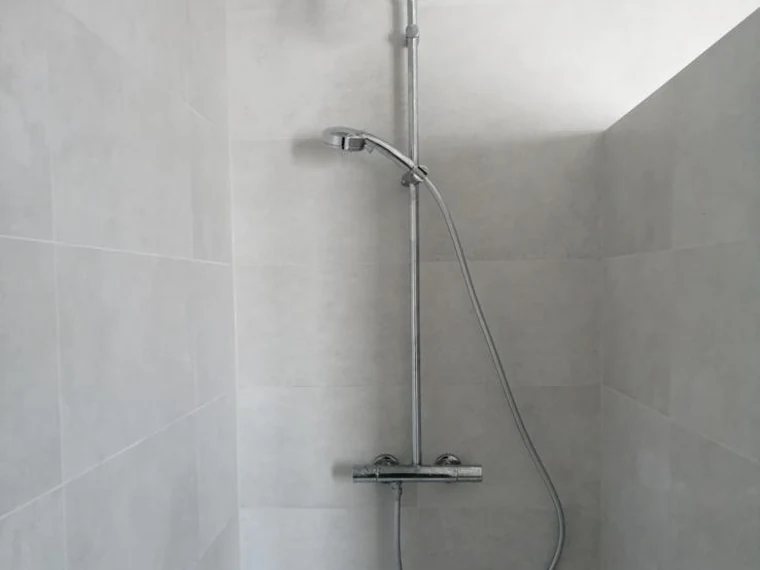 Colonne de douche thermostatique dans une douche carrelée
